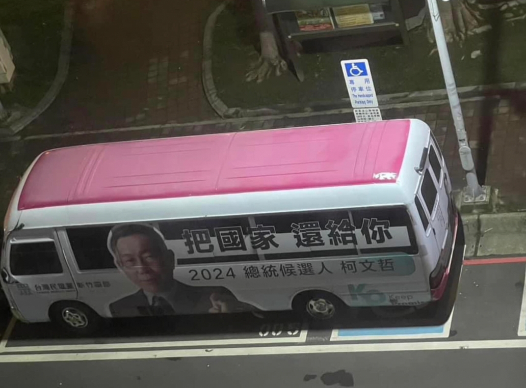 有網友拍攝到一輛粉紅色車頂，車側印有柯文哲照片及招牌「把國家還給你」標語的中型巴士，臨停在路邊車格，然而因其車身較長，竟橫跨至一旁身障專屬車位。 圖：擷自臉書「朗員大」