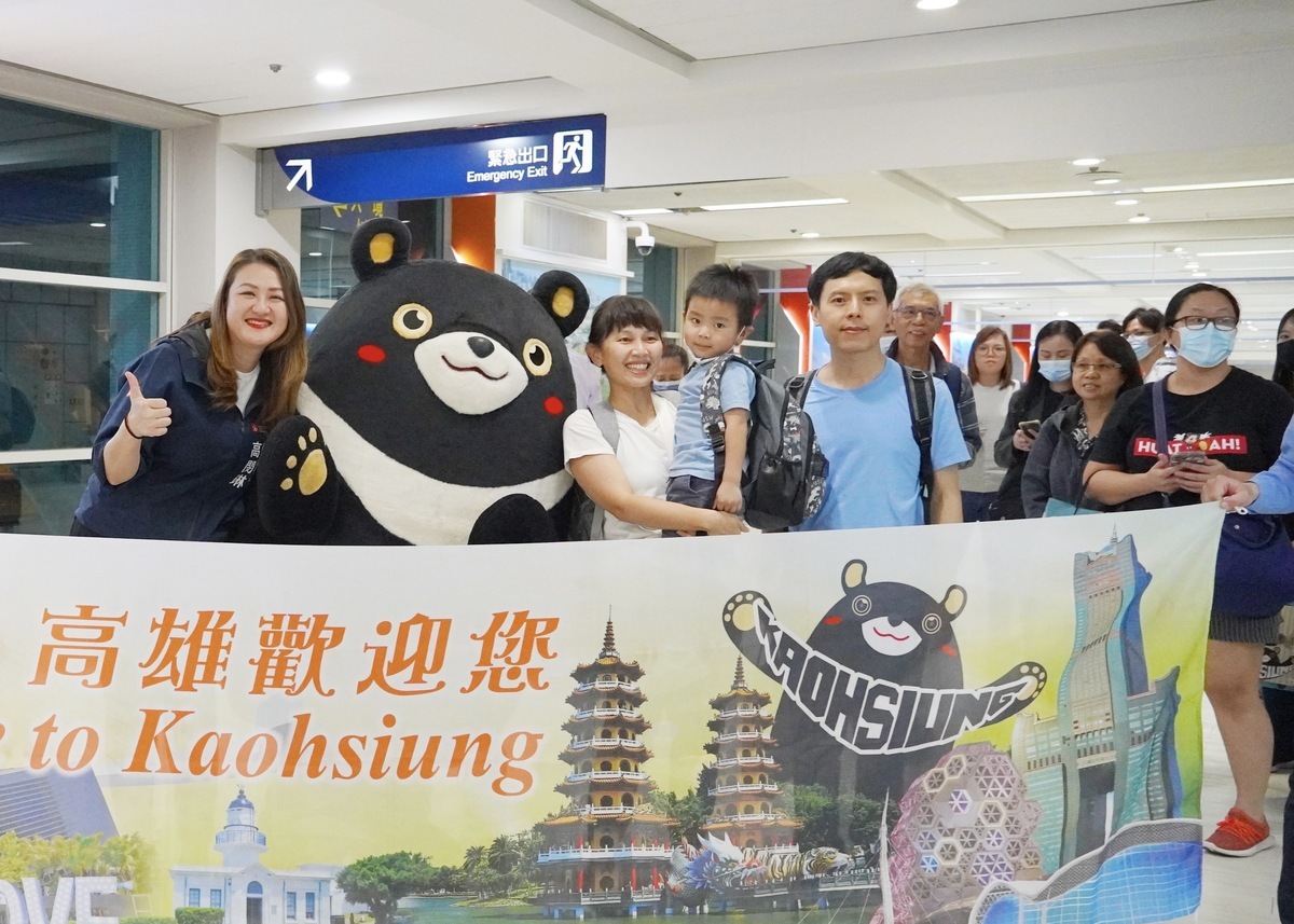 高閔琳(左一)、高雄熊(左二)致贈伴手禮歡迎新加坡旅客。 圖：高雄市觀光局/提供