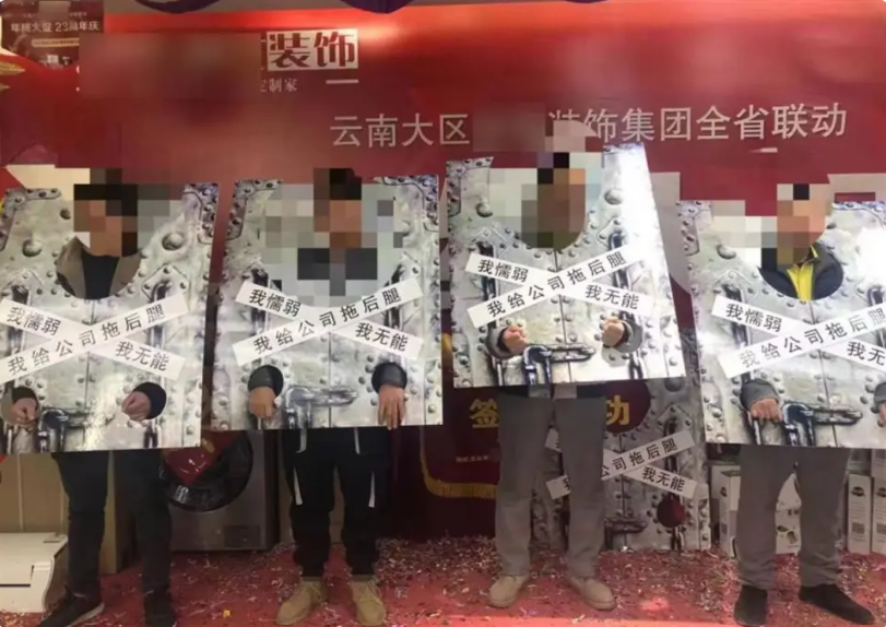 網絡上流傳一張中國服飾公司給業績落後員工帶枷鎖的照片，上面還寫有「我懦弱、我無能、我給公司拖後腿」的字樣。 圖：翻攝自「極目新聞」