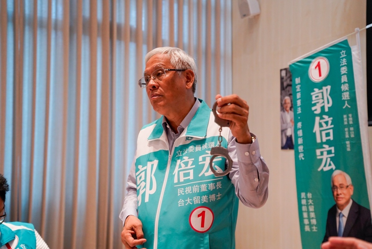 郭倍宏在記者會上出示一副手銬。 圖：郭倍宏競總/提供