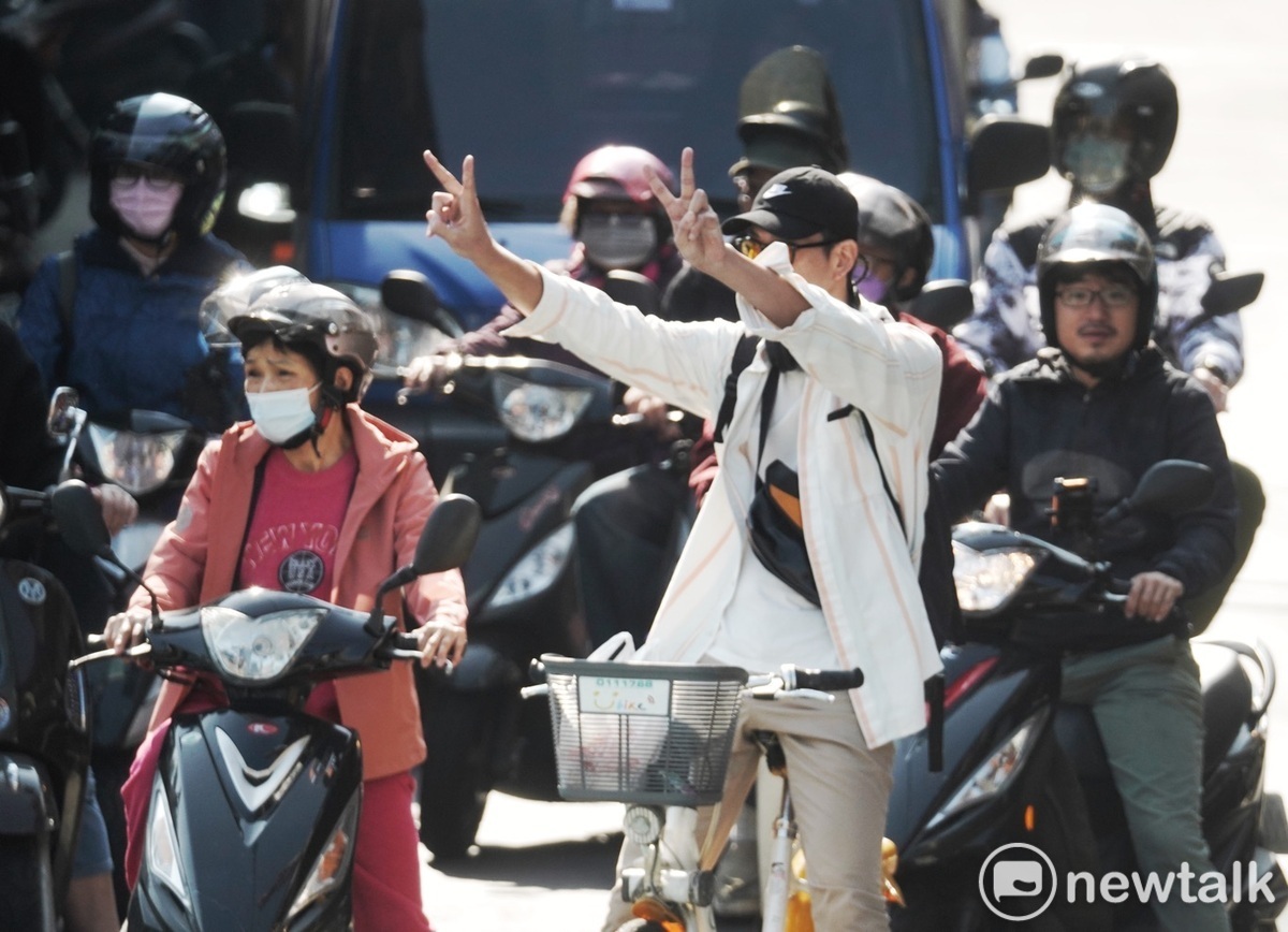 一位騎單車民眾對著國民黨總統候選人侯友宜比出賴蕭配的2號手勢。 圖：張良一/攝