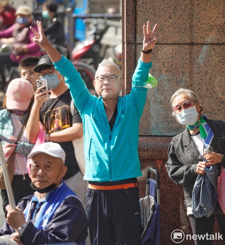一位民眾高舉雙手比出侯康配的三號手勢向侯友宜表達支持之意。 圖：張良一/攝