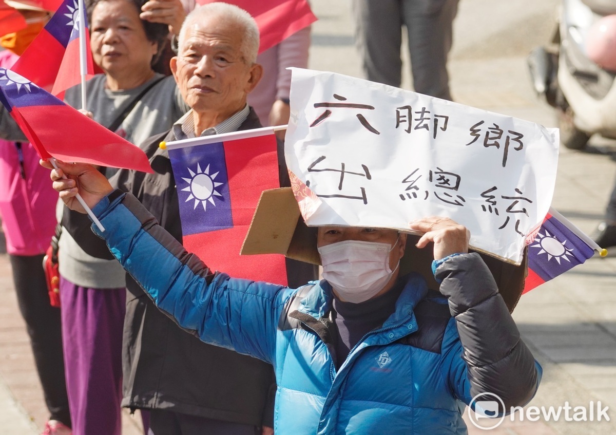 一位民眾拿著「六腳鄉出總統」的手舉牌向侯友宜表達支持之意。 圖：張良一/攝