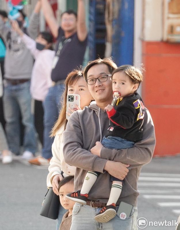 年輕的柯文哲支持者帶著幼兒在路旁歡迎柯文哲的到來。 圖：張良一/攝