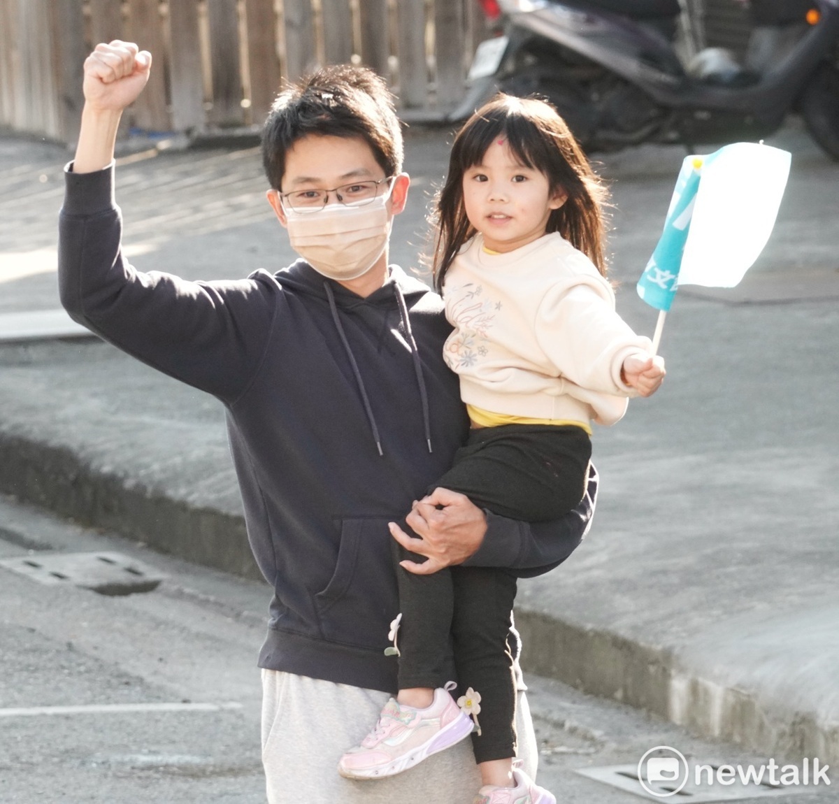 年輕的柯文哲支持者帶著幼兒在路旁歡迎柯文哲的到來。 圖：張良一/攝