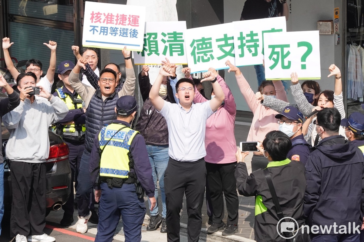 一些民眾舉著「賴清德支持廢死？」手舉牌，在車隊經過時對著賴喊口號比倒讚。 圖：張良一/攝