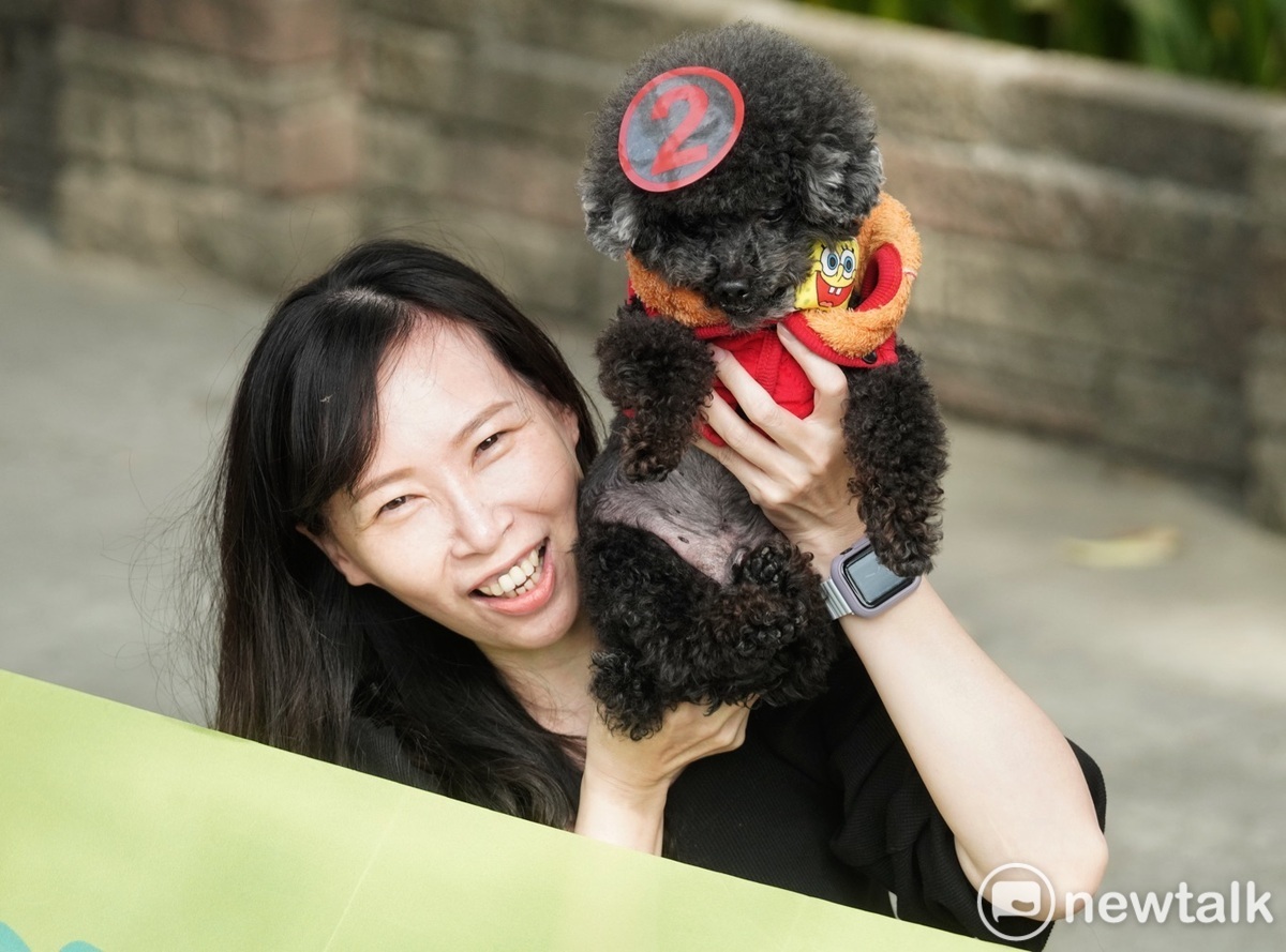 台南一位年輕女性將2號貼紙貼在她的狗狗頭上。 圖：張良一/攝