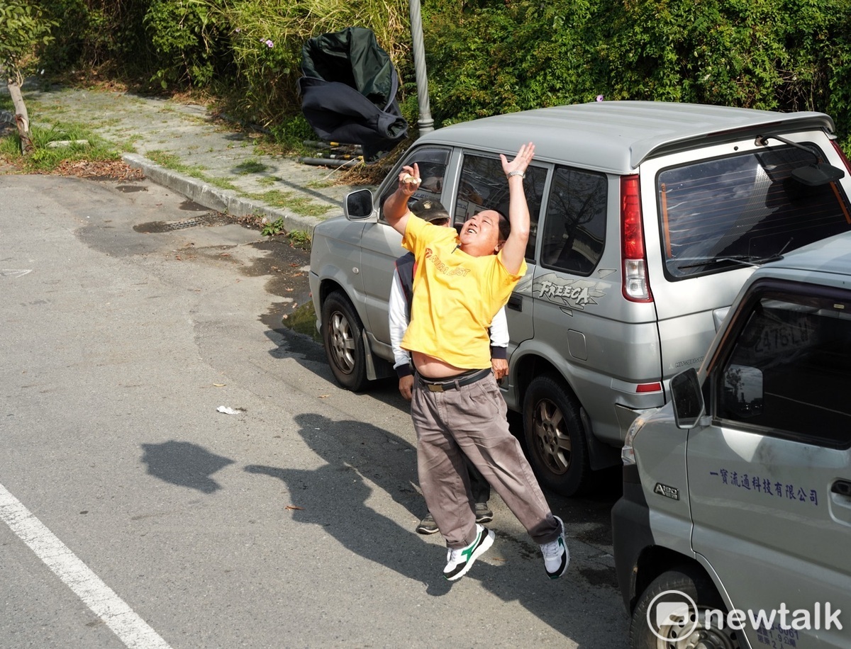 賴清德掃街車隊經過台南市區時，一位民眾興奮的跳起來並將他的外套往上拋。 圖：張良一/攝