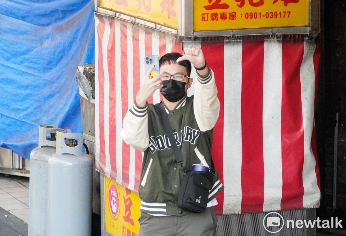一位年輕的男性選民用手機拍下他對賴清德比出倒讚。 圖：張良一/攝