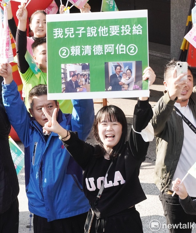 賴清德掃街車隊在台中市豐原區掃街拜票時，一位年輕媽媽拿著「我兒子說他要投給2號賴清德」的手舉牌，表達支持之意。 圖：張良一/攝