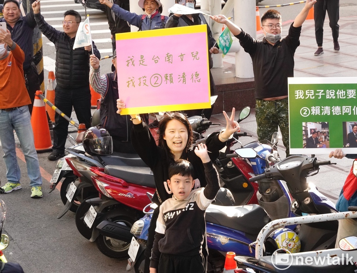 賴清德掃街車隊在台中市豐原區掃街拜票時，一位年輕媽媽帶著孩子，高舉票投賴清德的手舉牌，向賴加油打氣。 圖：張良一/攝