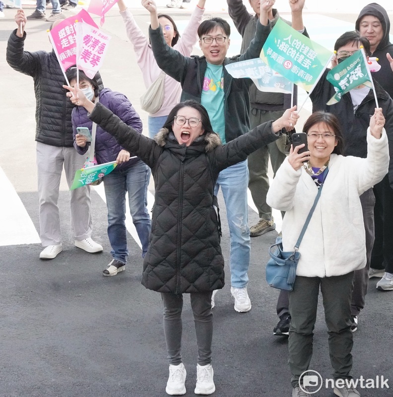 台中市區一位女性選民在賴清德掃街車隊經過時，雙手高舉賴清德蕭美琴的競選旗幟，表達支持之意。 圖：張良一/攝