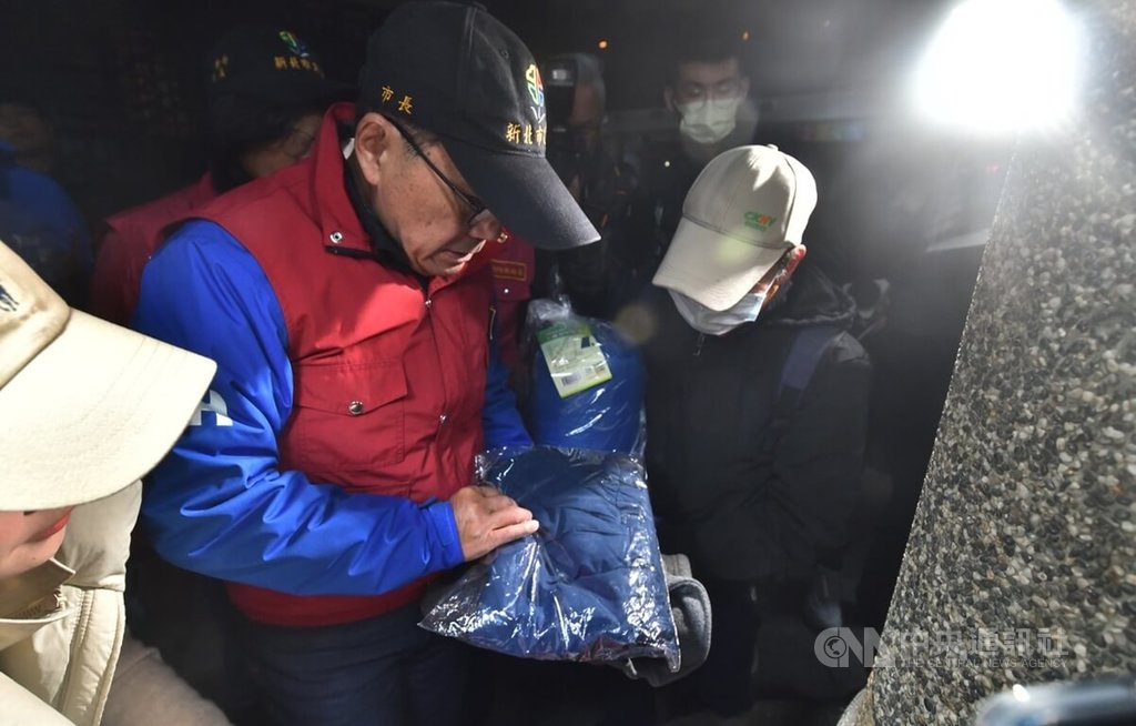 寒流影響氣溫驟降，新北市也啟動低溫關懷機制，市長侯友宜（中紅色背心者）21日晚間親自前往探視街友並分發禦寒物資，盼助弱勢民眾平安度過寒冬。 圖：中央社提供