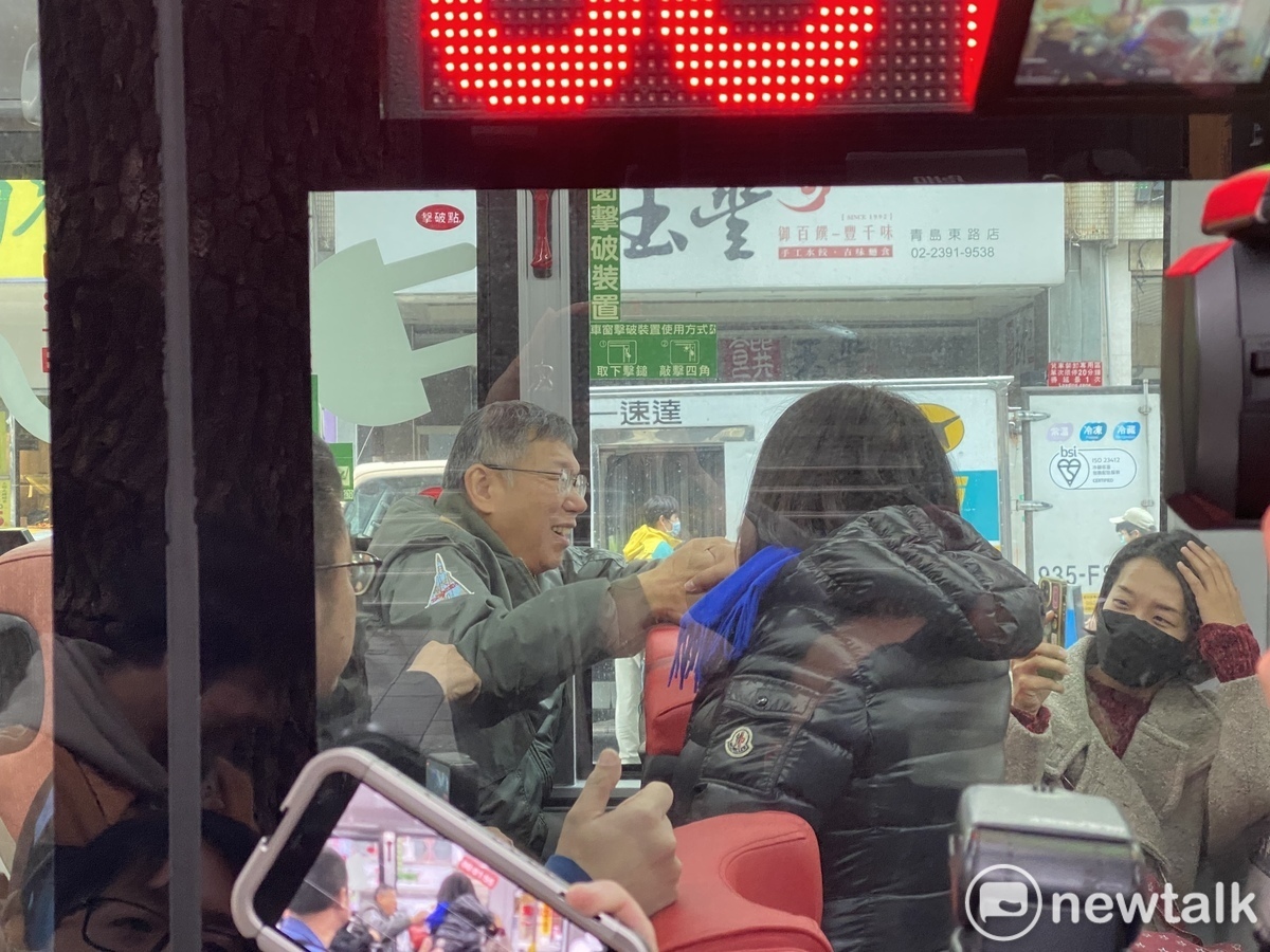 民眾黨主席柯文哲搭公車，國民黨立委陳玉珍衝上車致意。 圖：周煊惠 / 攝