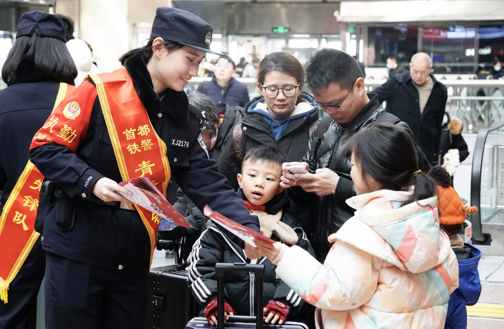 因應春運帶來的巨大人流量，北京鐵路公安局民警在北京西站發放出行安全宣傳單。 圖：翻攝自新華網