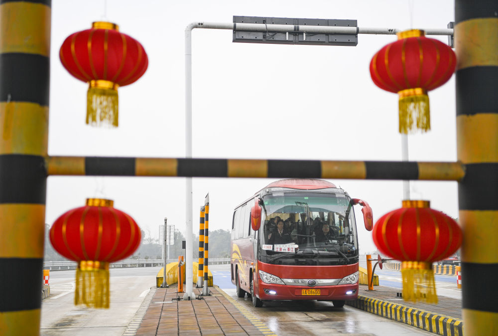 公共汽車經過重慶繞城高速公路收費站，滿載著準備回鄉團圓的民眾。 圖：翻攝自新華網