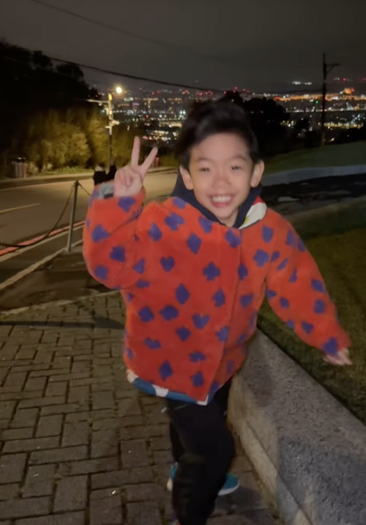 蔡桃貴在陽明山上拍照時，因為風太大導致完全站不穩，儘管如此蔡桃貴仍堅持比著剪刀手手勢、面帶微笑的拍照。 圖：翻攝自蔡桃貴IG