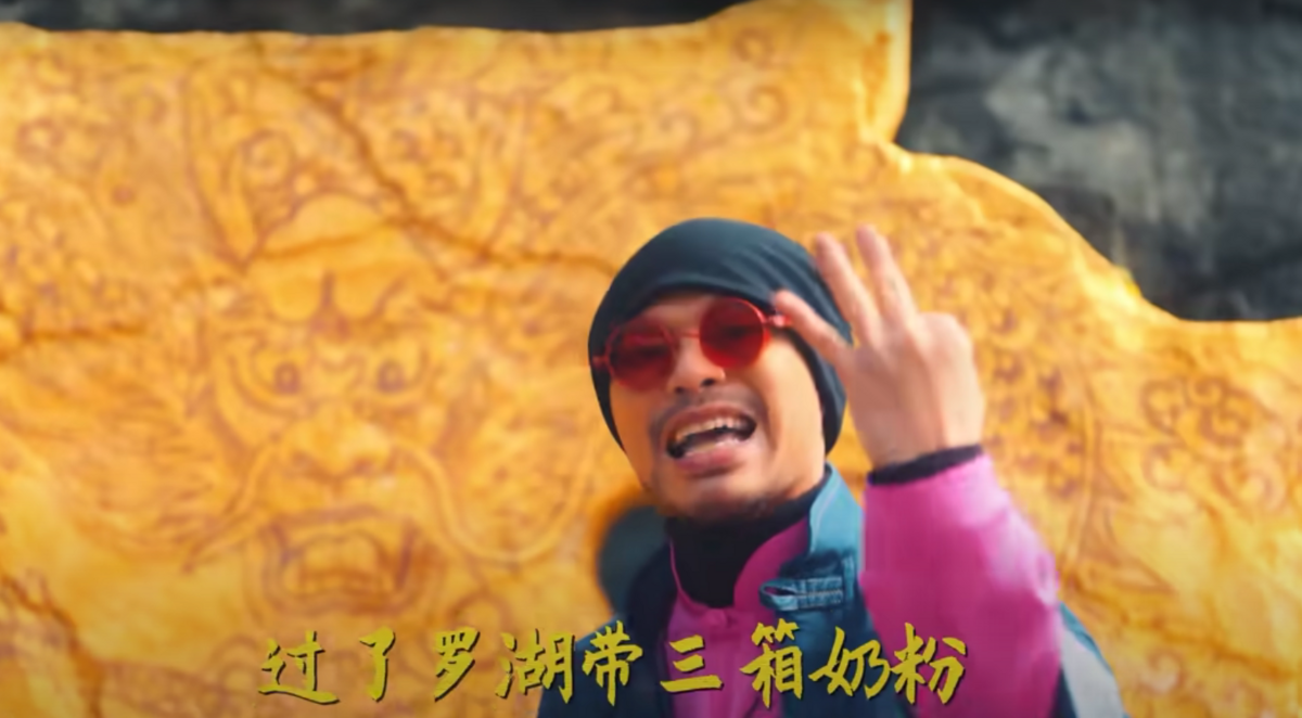 歌詞「過了羅湖帶了三箱奶粉」嘲諷中國人因為「三聚氰胺」事件不敢喝國產奶粉，造成大批「水貨客」到香港購買奶粉帶回內地轉售。 圖：翻攝自黃明志Youtube頻道「Namewee」