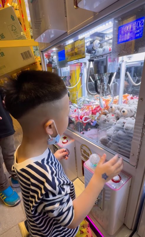 蔡波能一臉認真的看著機台裡的棕色小熊玩偶一邊操控搖桿，結果爪子勾到玩偶的手順勢將整隻玩偶拉進洞，只夾了一次就順利出貨。 圖：翻攝自蔡波能IG