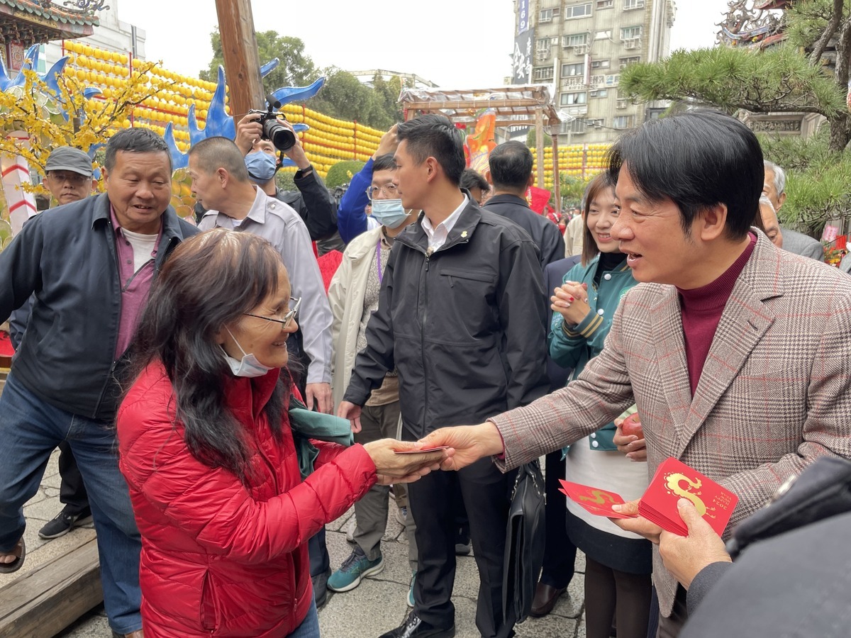 賴清德向民眾發放一元福袋。 圖：翻攝自 財團法人台北市艋舺龍山寺臉書