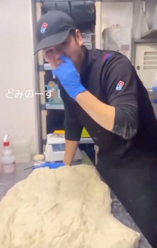 一名廚房中的男性打工人員原先正揉製麵糰，豈料卻將手指伸進鼻孔，並開始以該手置於麵團表面摩擦。 圖：取自「X」@bakusai_com