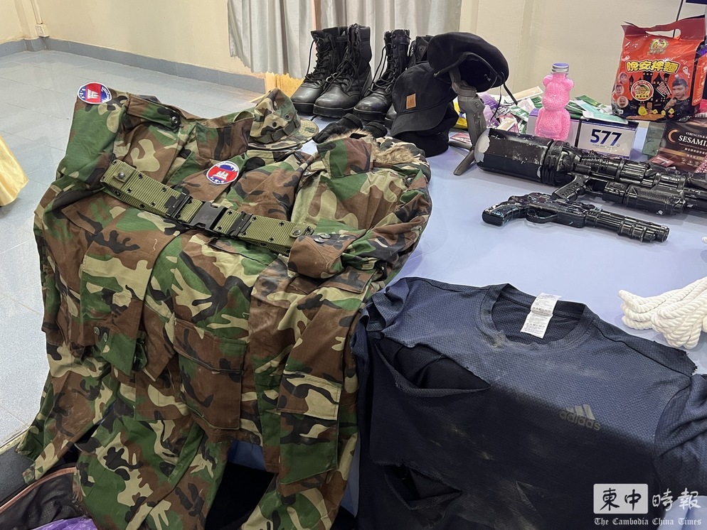 西哈努克省警察局於今日下午召開記者會，警方在現場展示了「晚安小雞」持有的鬼臉面具、衣服、軍裝、假槍、理髮器，以及用來冒充鮮血的紅色液體等工具。 圖：翻攝自柬中時報