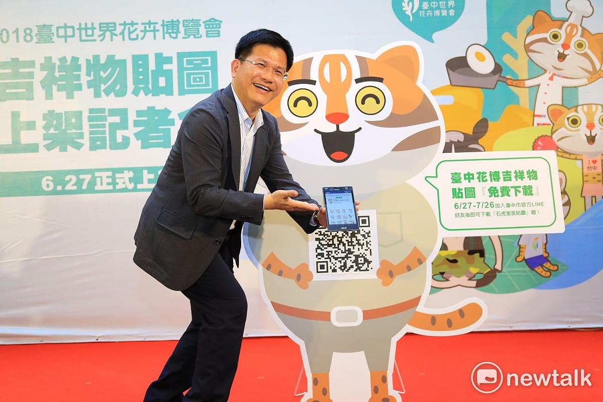 林佳龍以小平板掃描QR CODE，馬上成功下載石虎家族LINE貼圖。 圖：唐復年/攝