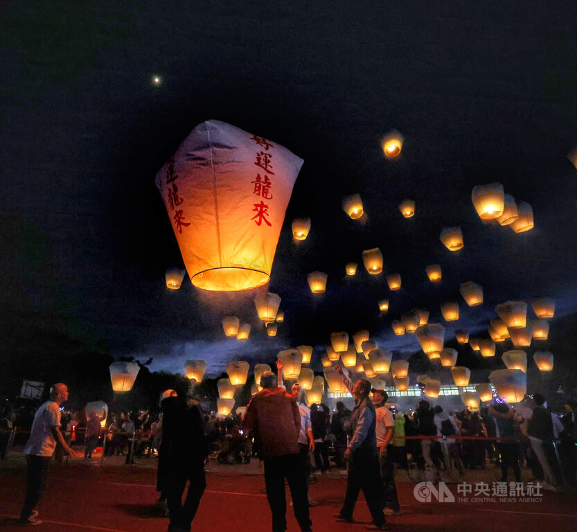 2024平溪天燈節17日晚間在新北市平溪國中舉辦首場活動，晚間民眾齊聚施放天燈，看著冉冉升空的天燈，祈求新年平安好運「龍」來。 圖：中央社提供