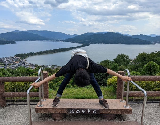 京都府宮津市的「天橋立」，是「日本三景」之一，當地流傳背對沙丘，透過跨下觀賞風景的經典姿勢。然而最近卻有遊客擺出此姿勢後遭同行友人推落山崖的意外發生。 圖：翻攝自@KIIfishingplus X帳號