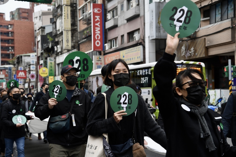 228事件77週年將至，228事件紀念基金會與228國家紀念館24日起舉行特展及系列活動，由多個民間團體發起的「228．0紀念行動」也在街頭登場，大批民眾身穿黑衣、手持紀念圓牌參與遊行。 圖：中央社