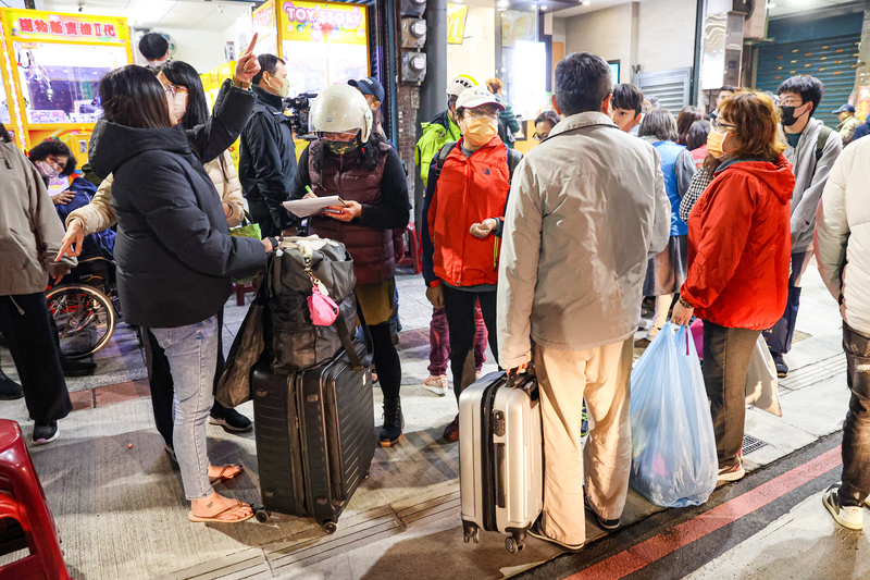 新北市三重區福隆路某工地27日施工時，突然發生滲水情形，並造成附近有建物些微傾斜，住戶晚間帶著簡單行囊，在市府人員引導下前往暫時居所。 圖：中央社