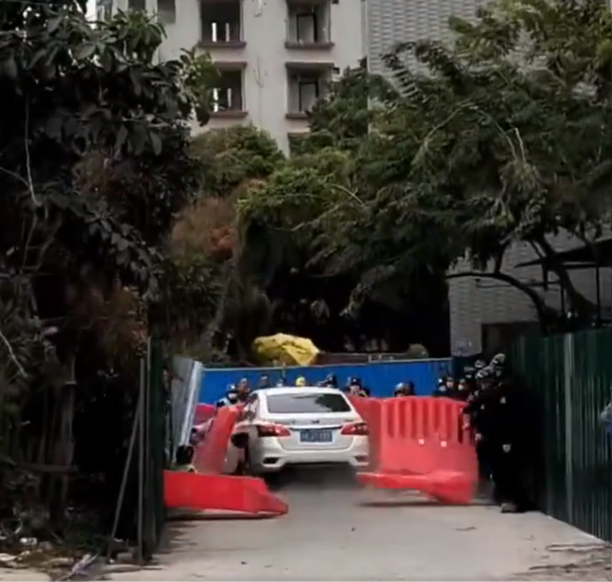 一群城管在廣東佛山窖口準備強拆一所違建民宅時，一輛轎車高速衝開圍欄，撞向城管。 圖：翻攝自希望之聲–中國時局 X（前推特）帳號