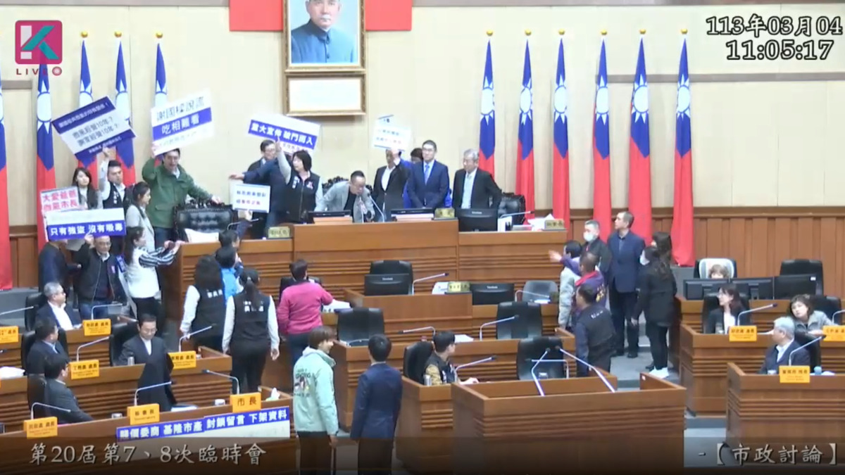 基隆市議會昨（4）天召開臨時會，市長謝國樑列席答詢。民進黨10位議員手舉「謝國樑說謊」、「吃相難看」看板包圍謝國樑，國民黨議員則上前護駕，雙方引爆衝突。 圖：截自基隆市議會議事影音平台。