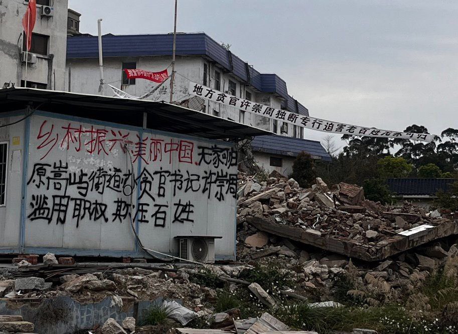 福建省廈門市海滄區鰲冠村的村民於被拆遷的廢墟上拉上標語，怒指政府濫用特權，欺壓老百姓。