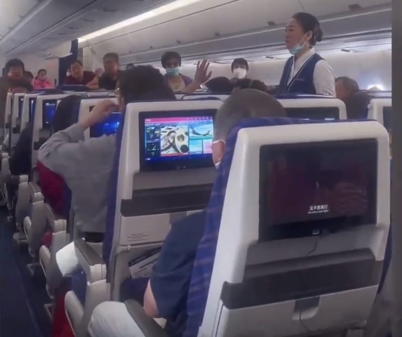 中國南方航空 6 日發生一起遊客向飛機引擎內部投擲硬幣的事件，造成該航班延誤 4 小時，空姐忙著安撫機上乘客。 圖：翻攝自騰訊網