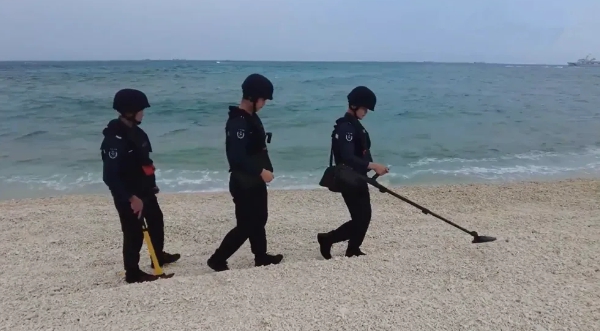 中國海巡人員在驅離菲律賓人員後，登上鐵線礁進行金屬探測檢查 圖 : 翻攝自河東三叔
