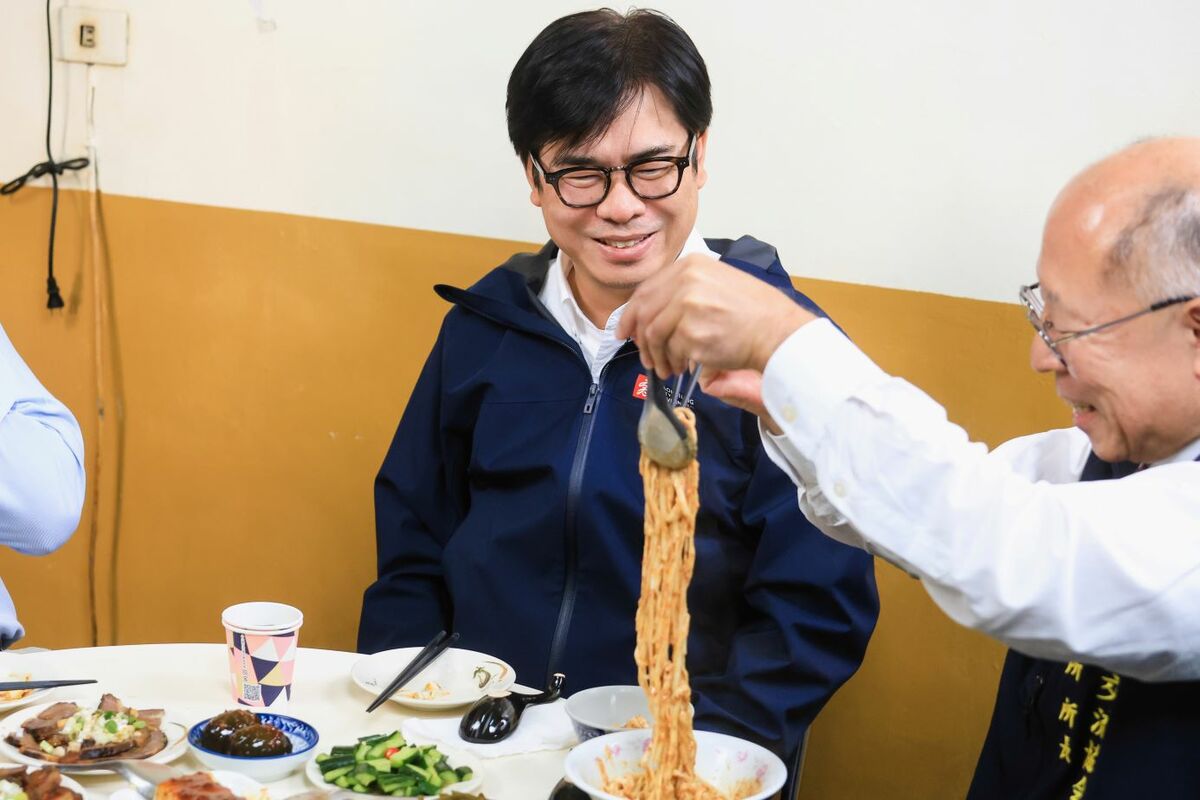 陳其邁（左）看著奧正史挑戰辣味擔擔麵。 圖：高雄市行國處/提供