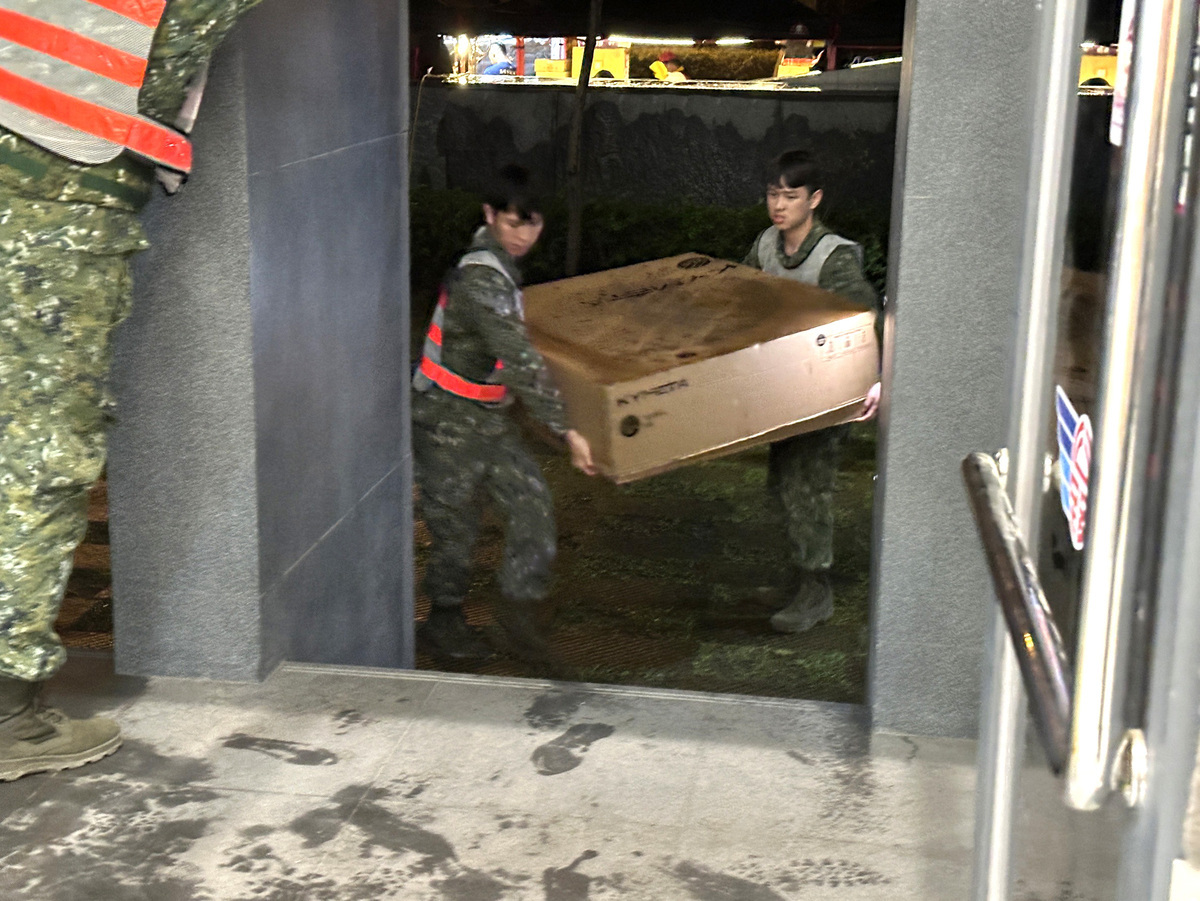 數位部在國防部與內政部空中勤務總隊直升機的協助下，接力運送低軌衛星通訊網路設備至災區。圖為國軍協助搬運低軌衛星接收設備。 圖：數位部提供