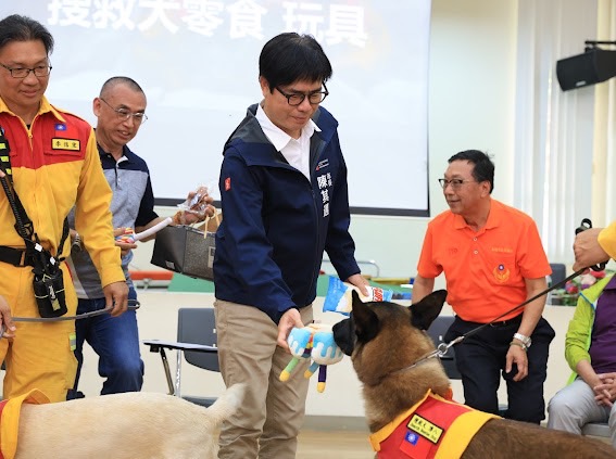 陳其邁(中)頒贈玩具給搜救犬。 圖：高雄市消防局/提供