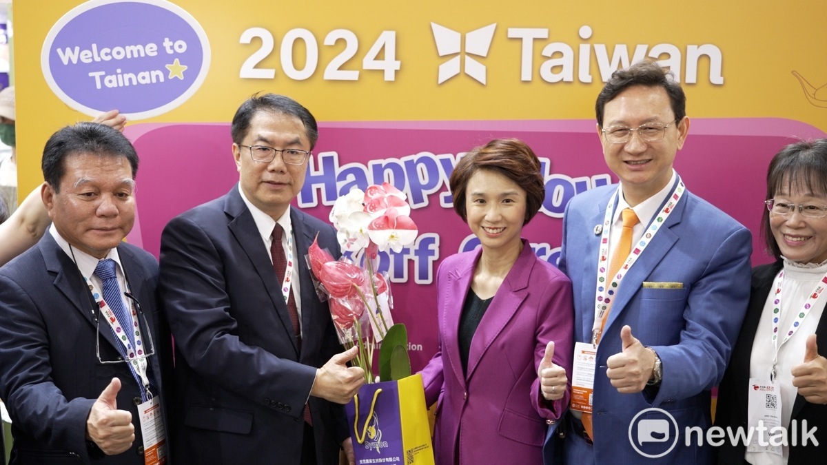 台南市長黃偉哲向劉燕玲部長展示新加坡國旗與台南市徽噴印蘭花與火鶴，祝福臺灣與新加坡都「呼賀」。 圖：台南市政府提供