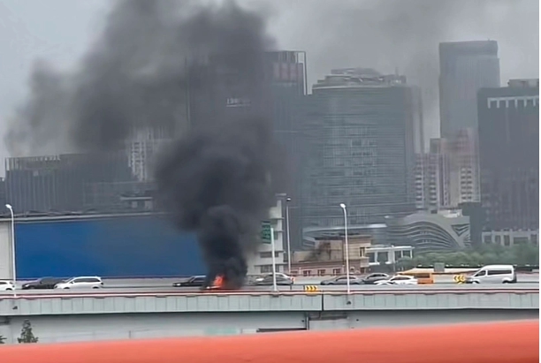 上海火燒車事件，事故發生在南浦大橋浦東往浦西方向下引橋處，一輛電動車有明火燃燒。 圖 : 翻攝自微博