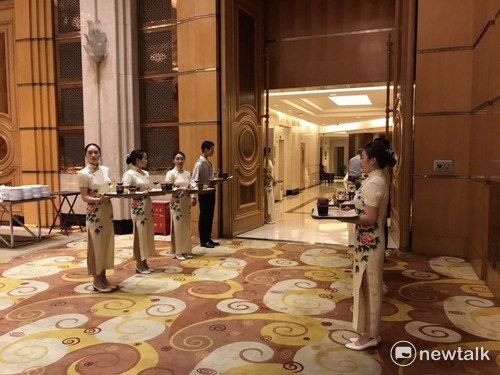 穿著旗袍的服務人員擺出專業姿勢。 圖：周煊惠/攝