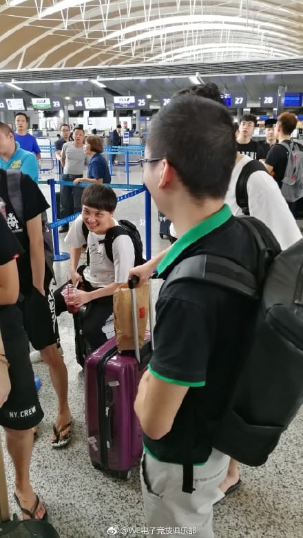 Team WE中路選手「xiye」（兮夜）坐在自己的行李箱上笑得俏皮。 圖：翻攝自WE 官方微博