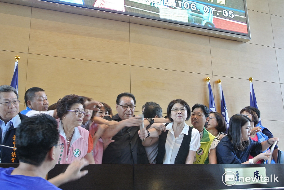 麥克風被折斷，議長林士昌（中）改用無線麥克風，民進黨議員團團圍住他要他快點宣布開會。 圖 : 唐復年/攝