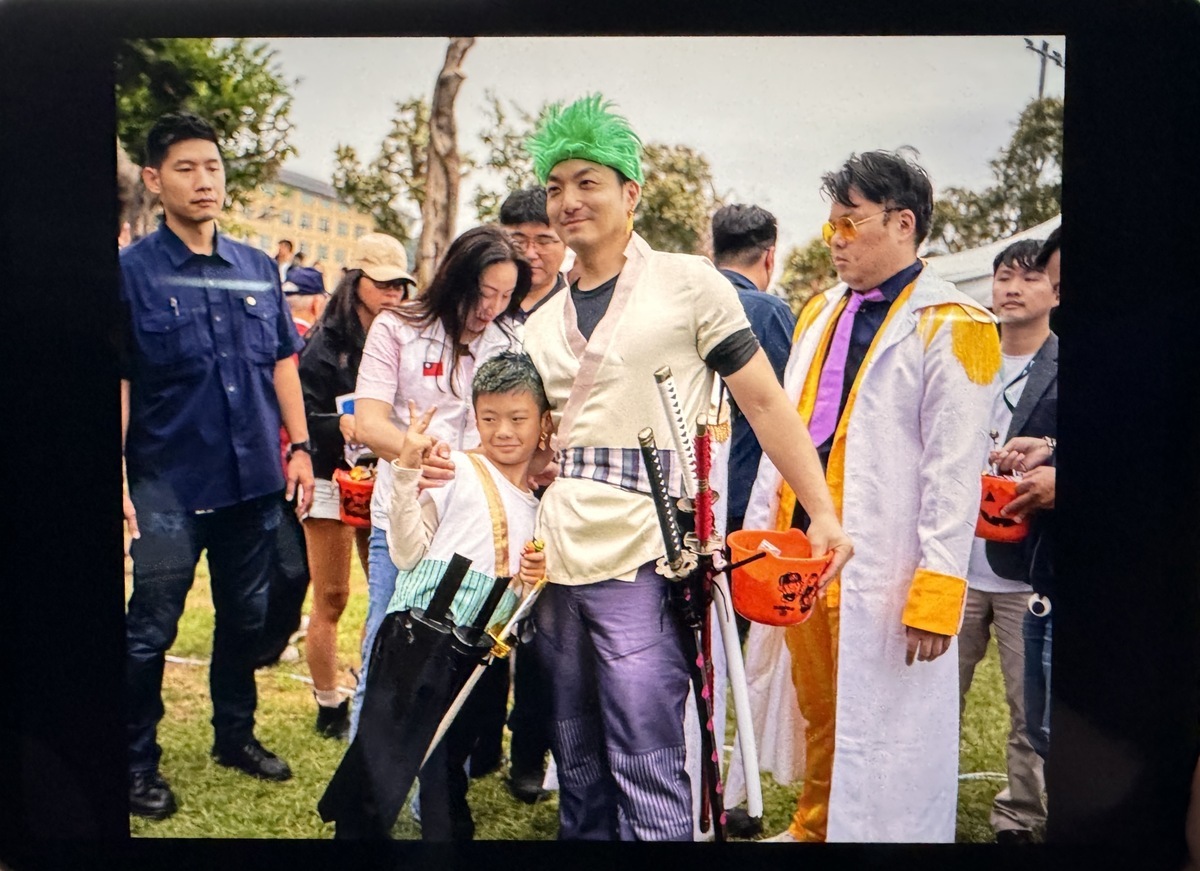 台北市長蔣萬安向日本前首相麻生太郎展示自己cosplay照片。 圖：台北市政府 / 提供
