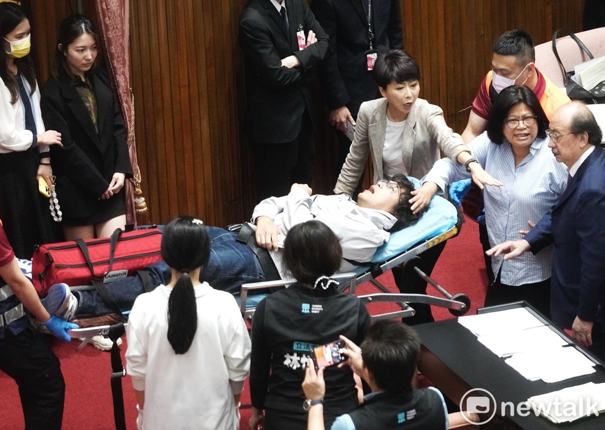 民進黨立委沈伯洋在藍綠肢體衝突中，被國民黨立委推下主席台，被醫護人員緊急送醫。 圖：張良一 / 攝