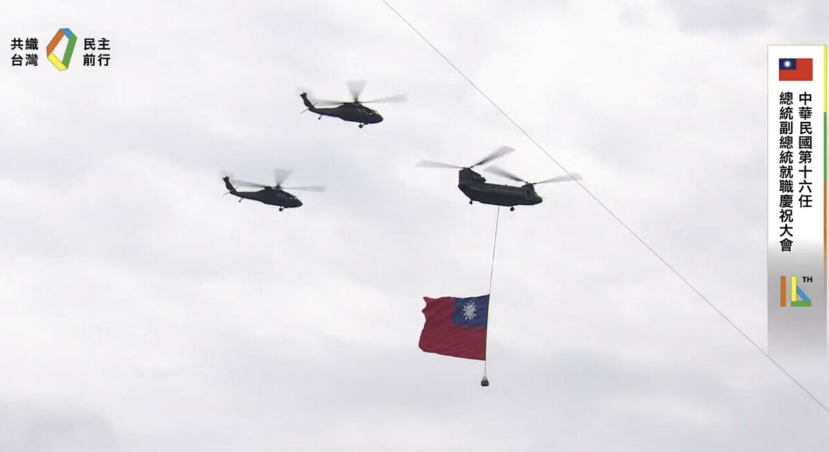 國防部表示，今（20）日領唱國歌時，由陸軍CH-47SD契努克中型運輸直升機，吊掛巨幅國旗1面，在2架UH-60M黑鷹直升機護衛下，搭配AH-64E、AH-1W攻擊直升機及海軍S-70C反潛直升機各3架，由北向南編隊飛行通過會場上空。 圖：翻攝自賴清德臉書直播