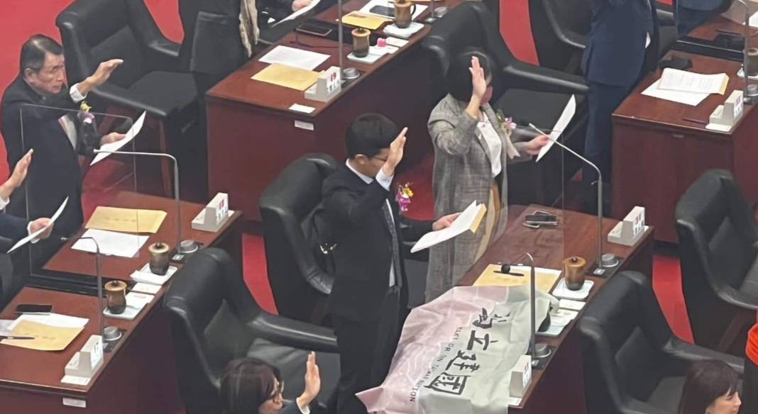 張博洋在高雄市議會對著桌上的台獨旗宣誓就職。 圖：台灣基進/提供