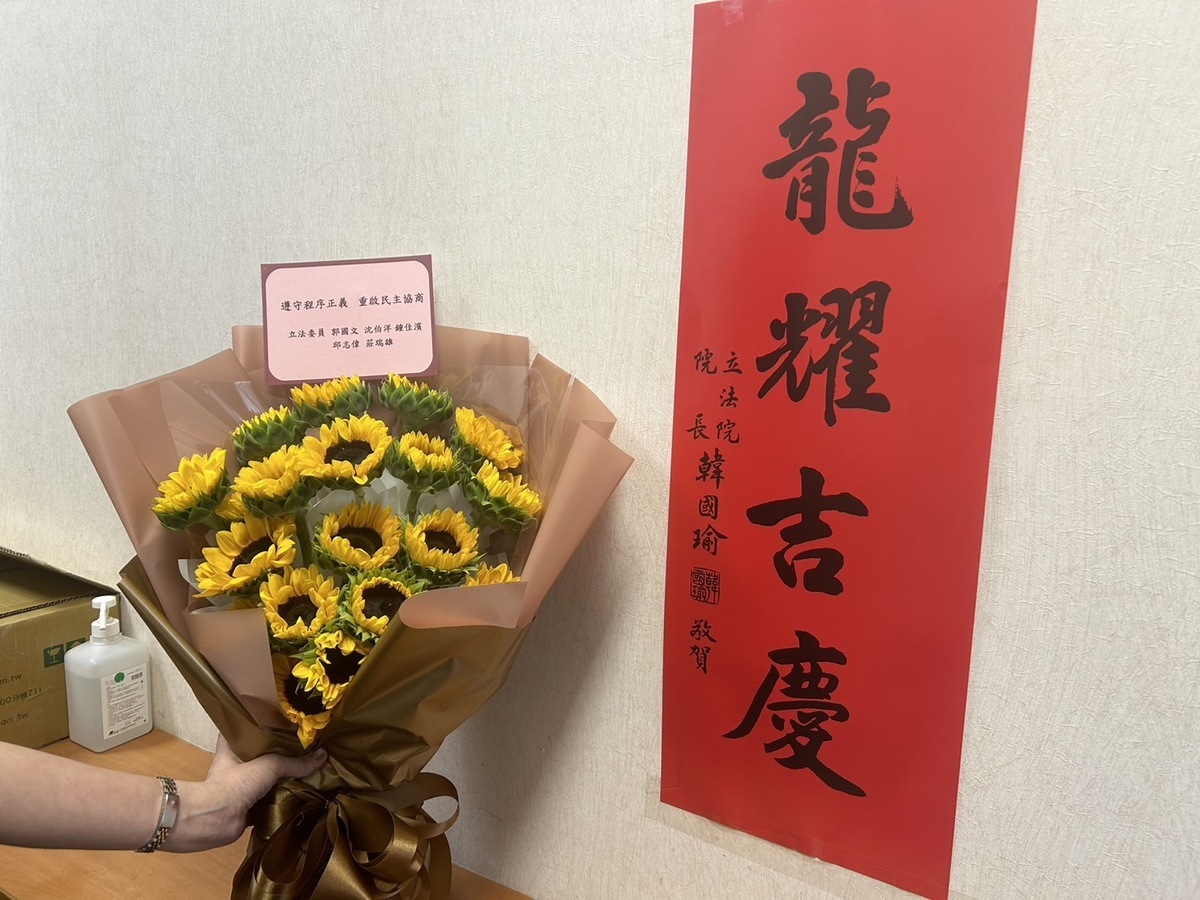 韓國瑜送花慰問掛彩立委，綠委回贈太陽花並署名「遵守程序正義，重啟民主協商」。 圖：立法委員郭國文辦公室提供