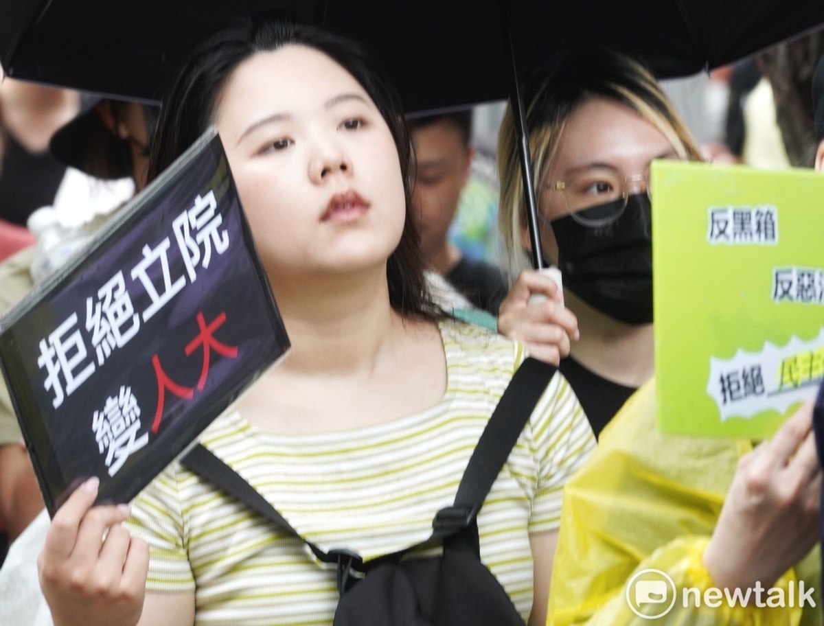 一位民眾高舉「拒絕立法院變人大」的手舉牌抗議國民黨和民眾黨欲強行通過國會擴權法案。 圖：張良一/攝